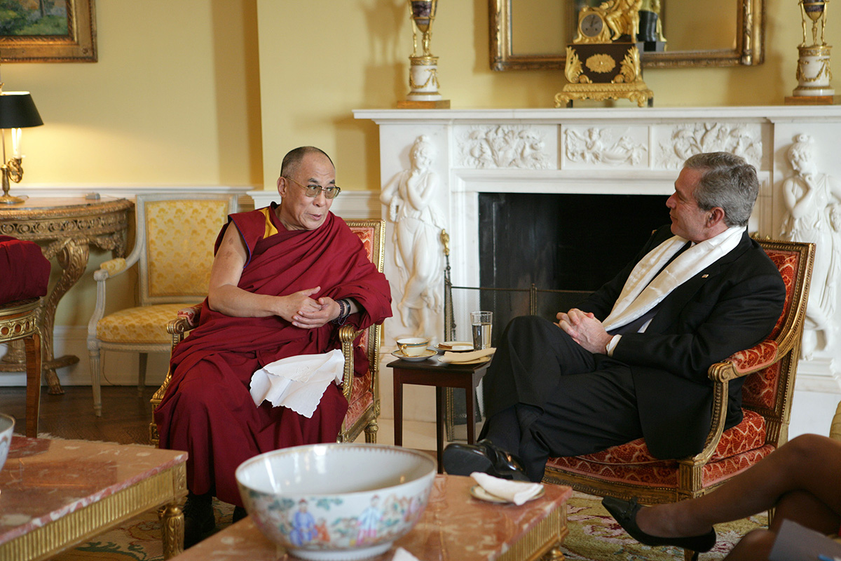 US President George W Bush wears a scarf that was presented to him by the Dalai Lama in the private residence of the White House in Washington, DC, on 9 November 2005.