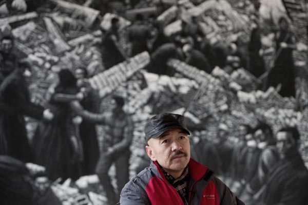 Artist Liu Yi poses in front of his painting of Tibetans