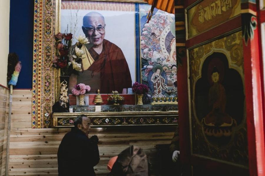 A man prays below a portrait of the Dalai Lama at Kirti Monastery in Aba, a Tibetan area of China’s Sichuan province.