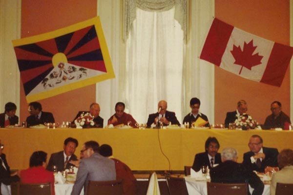 Tsering Wangkhang sitting in front of the Dalai Lama at a conference that he organized in Canada.