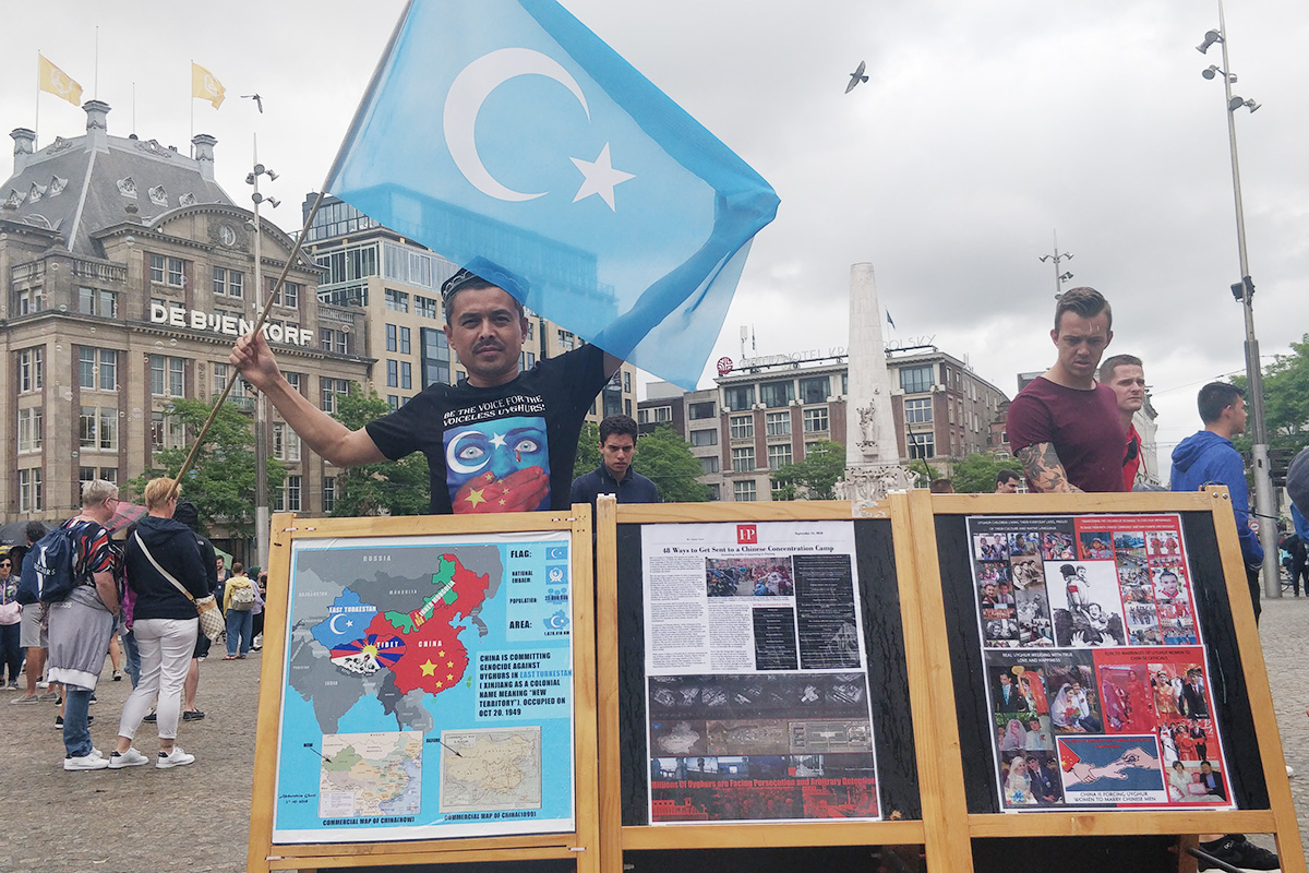 Uyghur freedom activist Abdurehim Gheni raises the flag of East Turkistan at his campaign spot at Dam Square in Amsterdam, The Netherlands, on 6 July 2019.