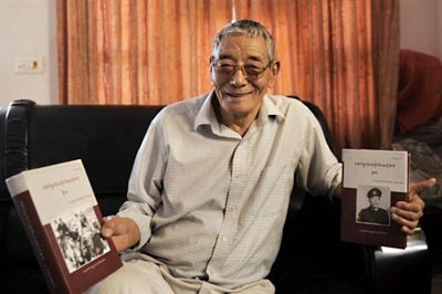 Ratu Ngawang, former guard of Tibetan spiritual leader the Dalai Lama, with his autobiography at his residence in New Delhi on 5 March 2009