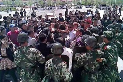 Mongolian Chinese paramilitary police officers scuffle with protesters in Shuluun Huh county of northern China's Inner Mongolia province.