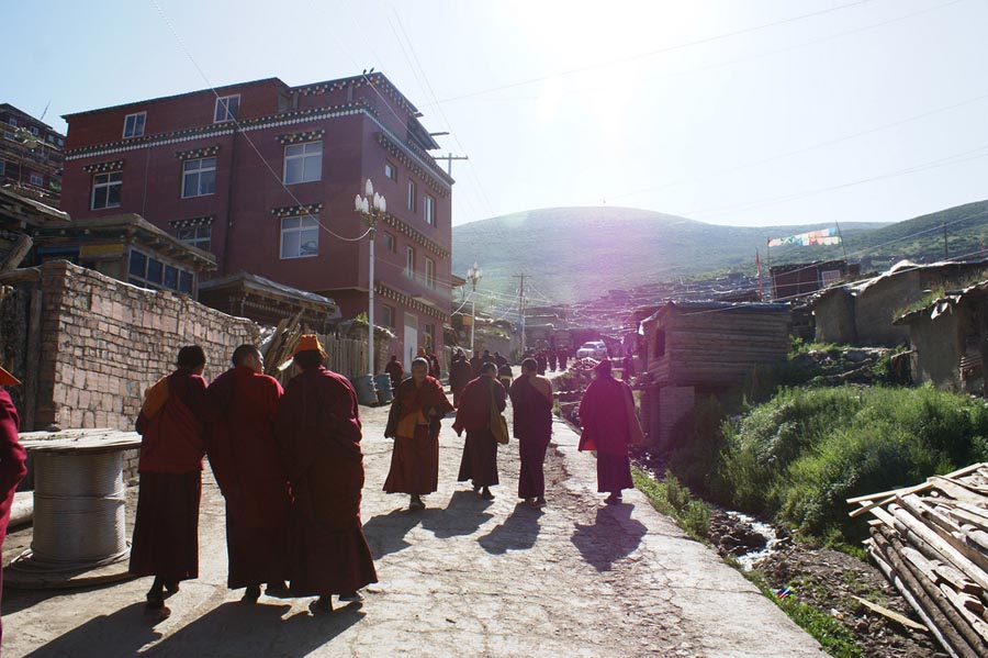 Tibetan Buddhist monks walk in the compound of Serthar Monastery in Tibet.