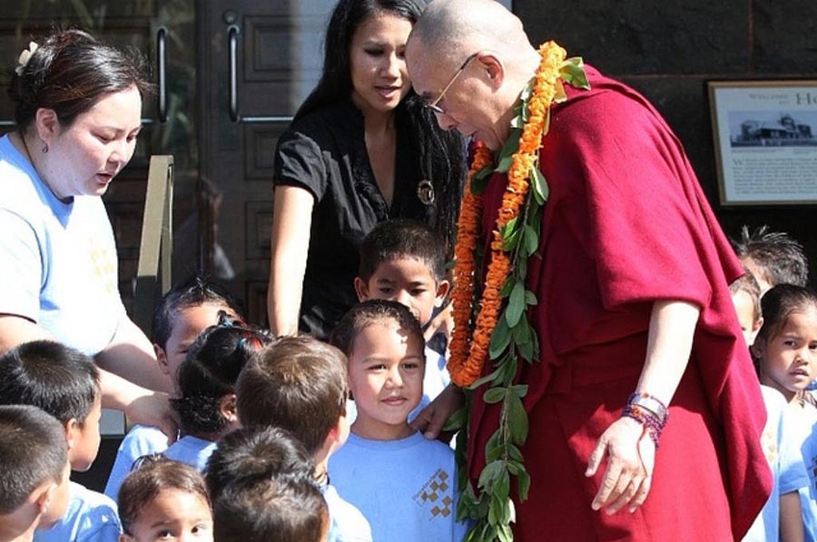 The Dalai Lama greets children outside on his tour of the Bishop Museum in Honolulu on 14 April 2012.