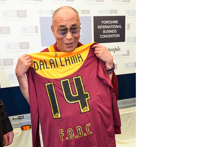 The Dalai Lama holding a Bradford City shirt.