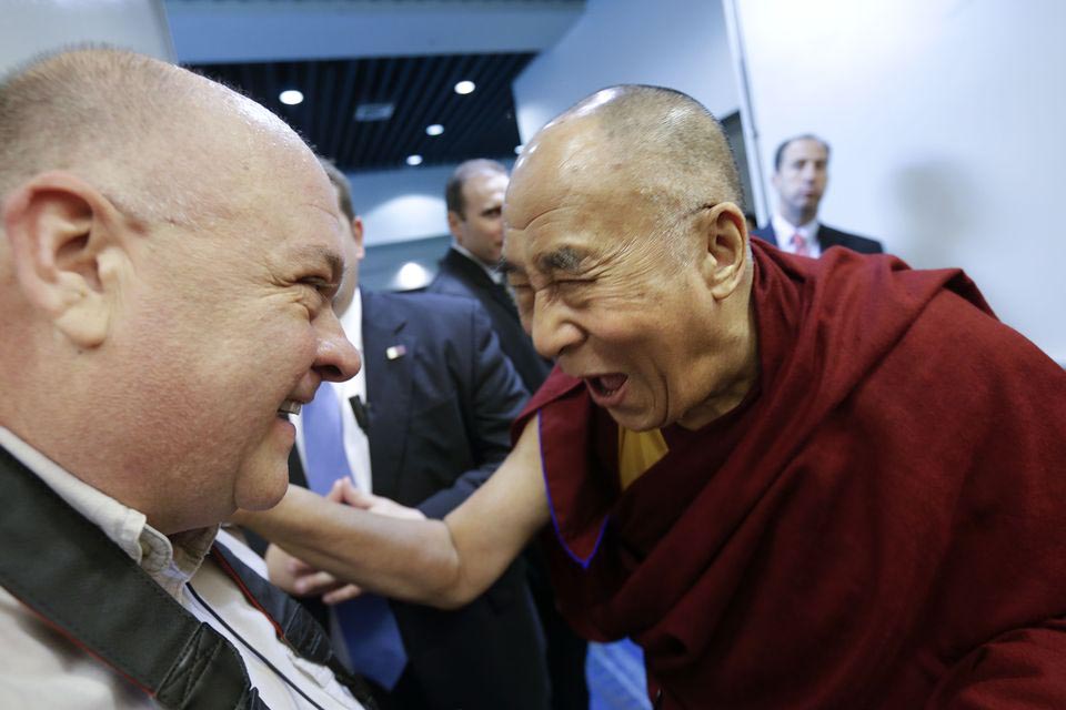 The Dalai Lama laughs as he banters about baldness