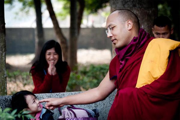 The 17th Karmapa Ogyen Trinley Dorje playing with a child