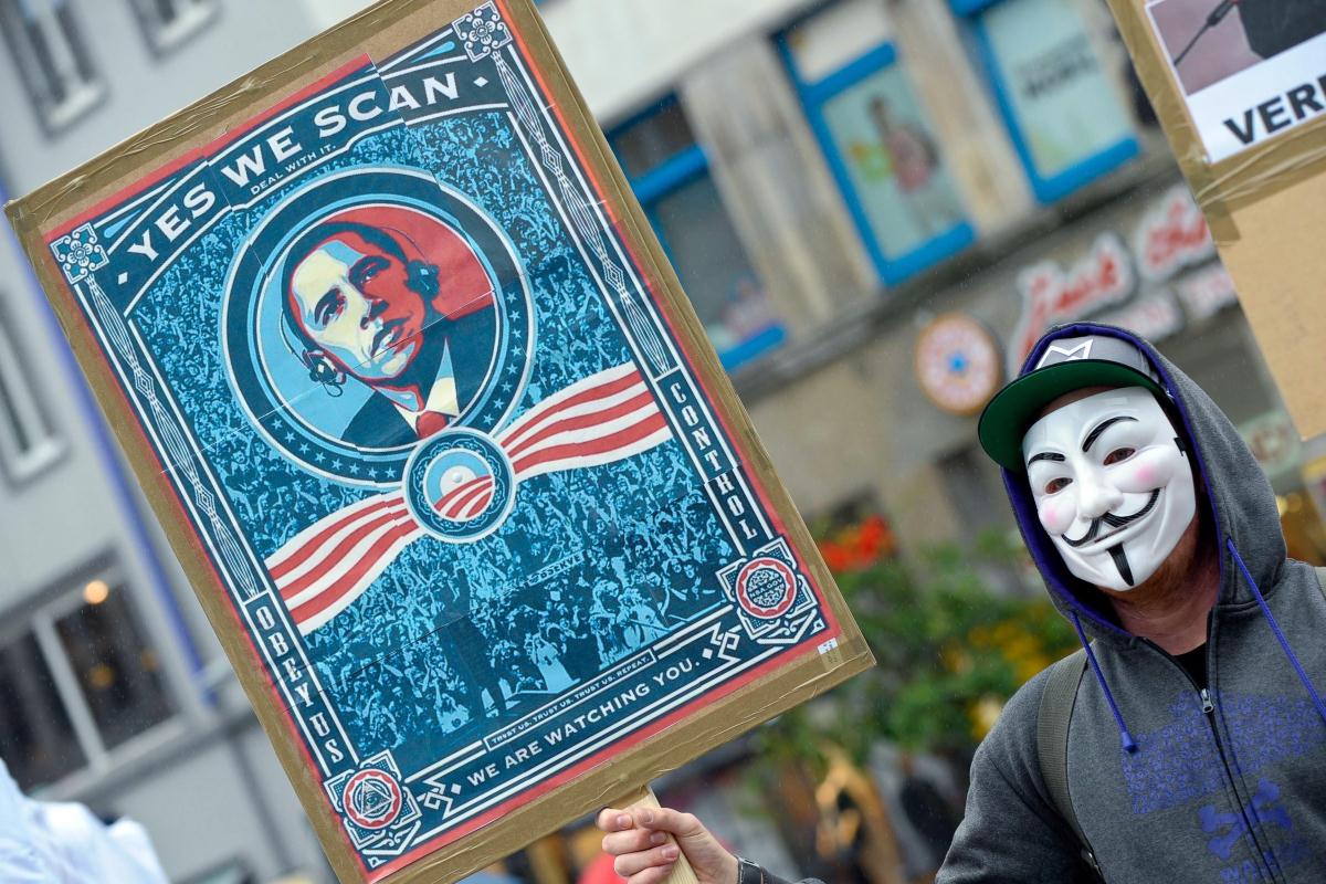 A demonstrator protests with a poster against NSA in Hanover