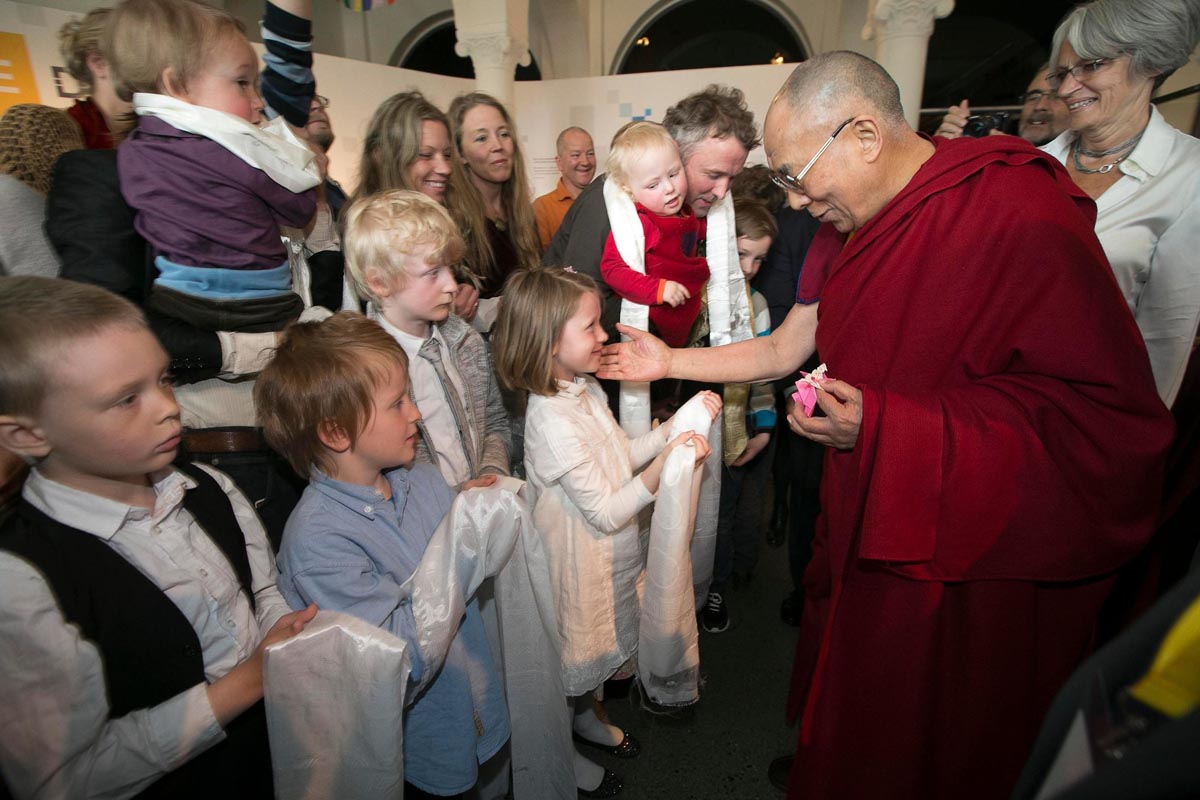 The Dalai Lama greeting children from a Buddhist school.