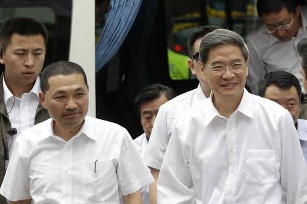 Zhang Zhijun (R), director of China's Taiwan Affairs Office, arrives with New Taipei City Deputy Mayor Hou You-yi at the labour activity centre in New Taipei City on 26 June 2014.