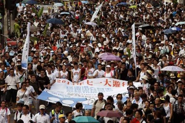 rotesters hold a banner which reads ''2014 July 1 mass march'' to demand universal suffrage in Hong Kong on 1 July 2014.