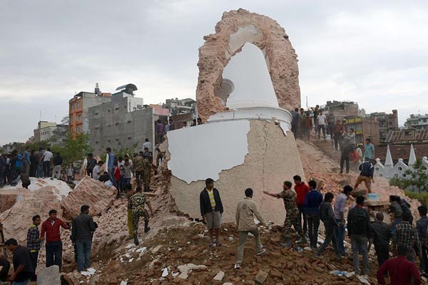 Nepalese rescue members and onlookers gather at the collapsed Dharahara Tower in Kathmandu on 25 April 2015.