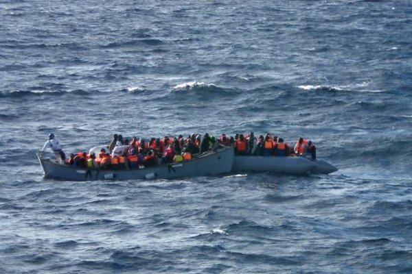 Migrants sit in a boat during a rescue operation off the coast of Sicily, in handout picture released by the Italian Navy on 4 December 2014.