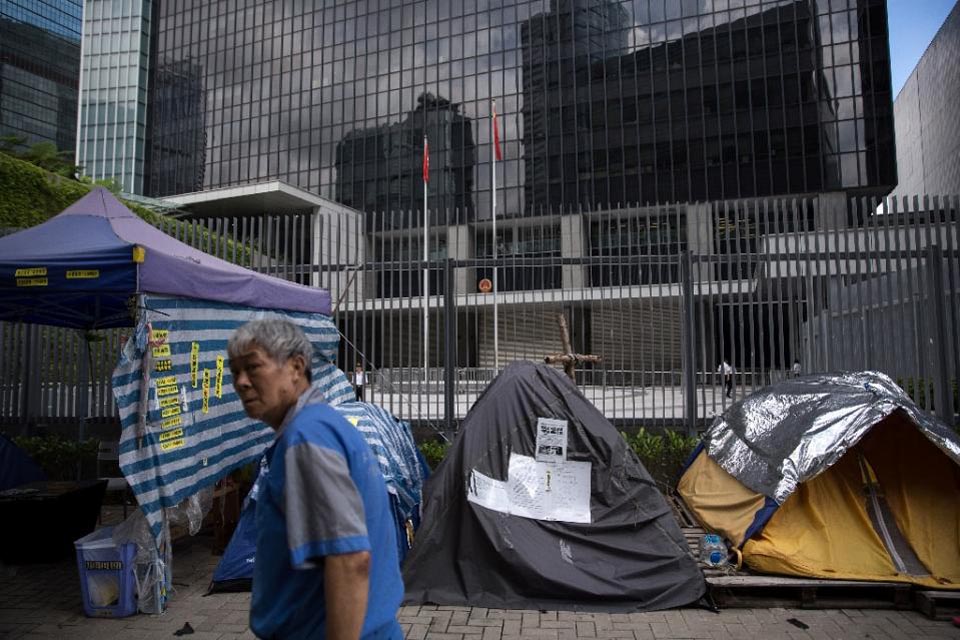 A man walks past tents setup by pro-democracy protesters on a sidewalk outside the government headquarters in Hong Kong, on 13 June 2015.