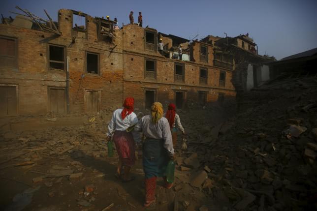 Women walk past collapsed houses as the wreckage is manually demolished following the April 25 earthquake in Bhaktapur, Nepal, on 5 June 2015.