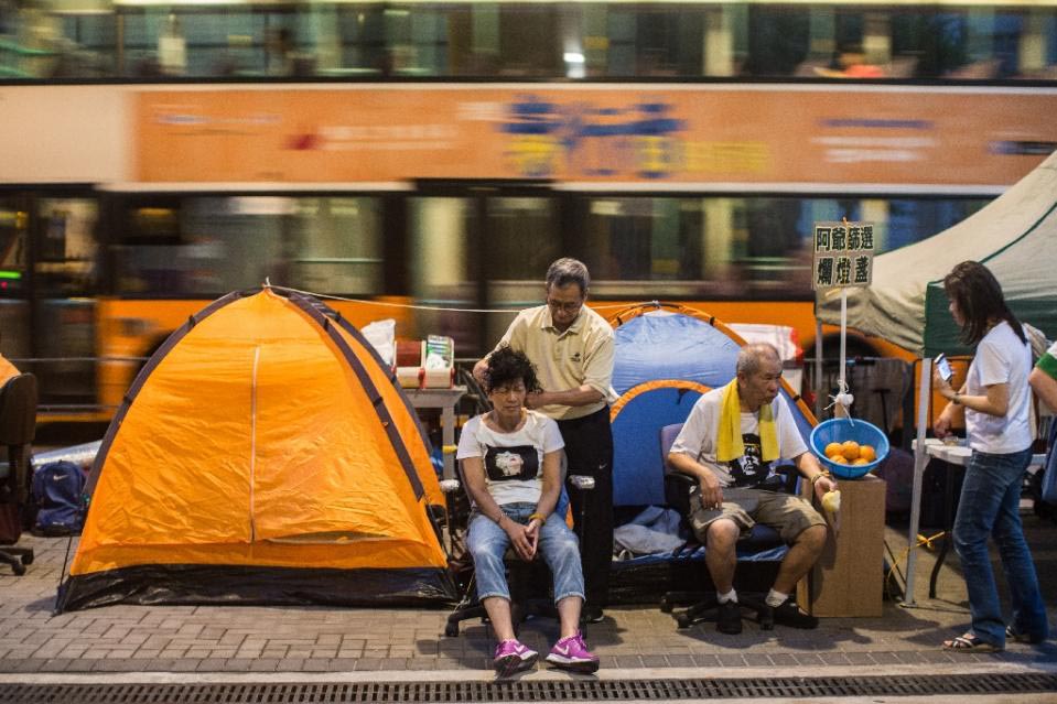 Pro-democracy activists sit alongside tents pitched outside the government offices in Hong Kong on 27 September 2015.