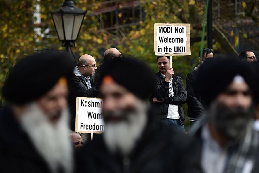 Protesters demonstrating against Indian Prime Minister Narendra Modi hold placards outside Downing Street in central London on 12 November 2015.