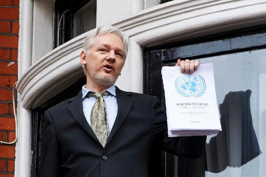 WikiLeaks founder Julian Assange addresses the media holding a printed report of the judgement of the UN's Working Group on Arbitrary Detention on his case from the balcony of the Ecuadorian embassy in central London on 5 February 2016.