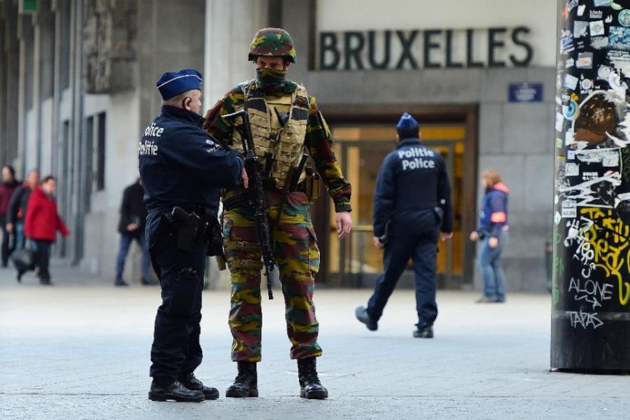 A Belgian soldier speaks to a police officer outside Brussels Central Station following attacks in Brussels on 22 March, 2016.
