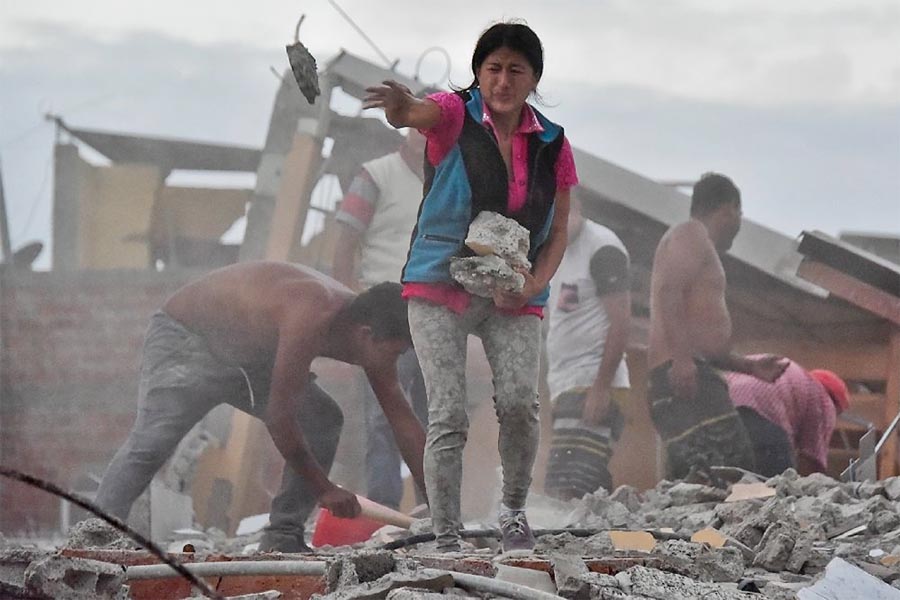 A woman removes rocks in a frantic search for her husband buried under the rubble in the Tarqui neigbourhood of Manta, Ecuador on 17 April 2016.