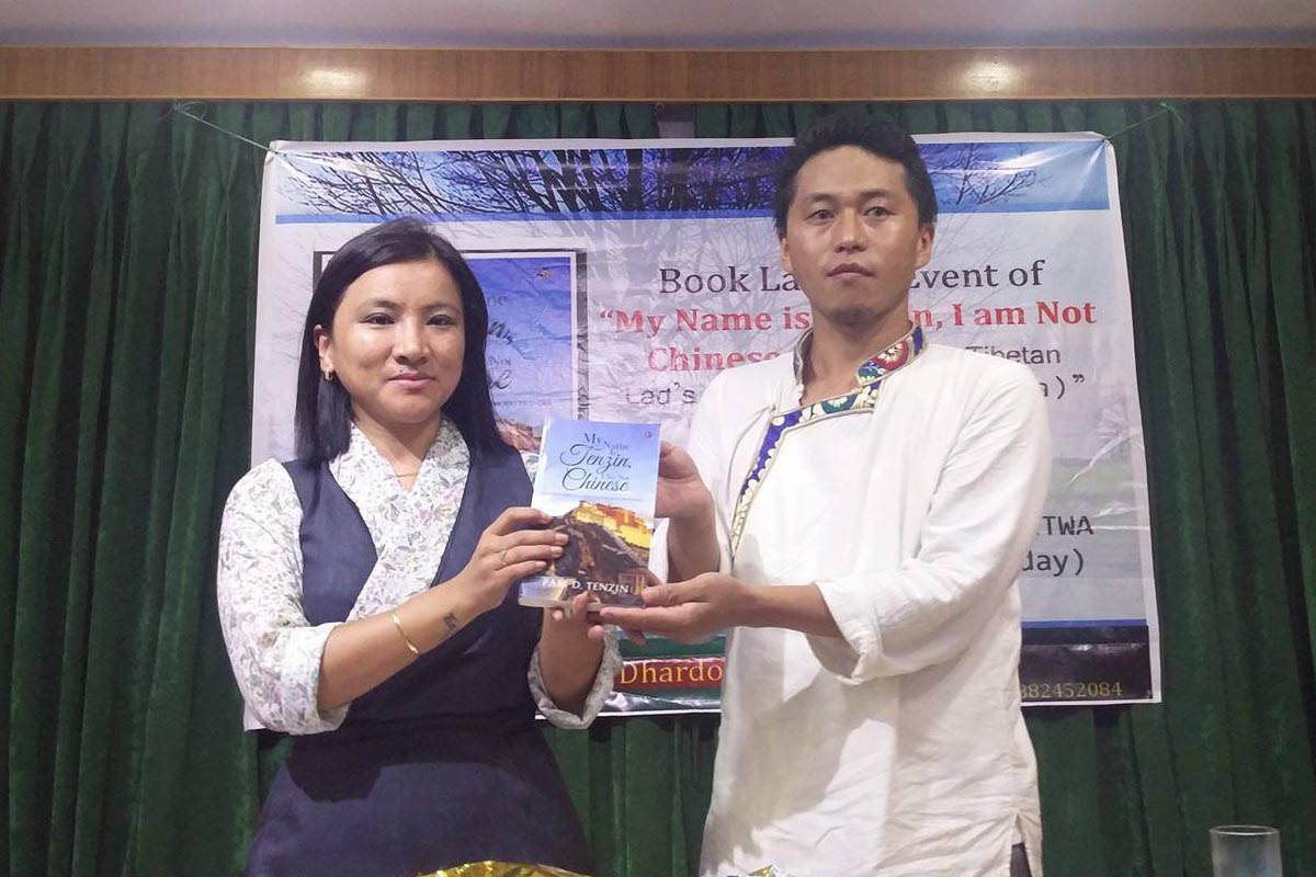 Dhardon Sharling displays debut book 'My Name Is Tenzin, I Am Not Chinese', with author Tenzin Phuntsok aka Pam D Tenzin, in Dharamshala, India, on 29 July 2016.