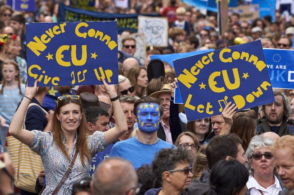 People hold up pro-Europe signs as thousands of protesters take part in a march through the centre of London on 2 July 2016.
