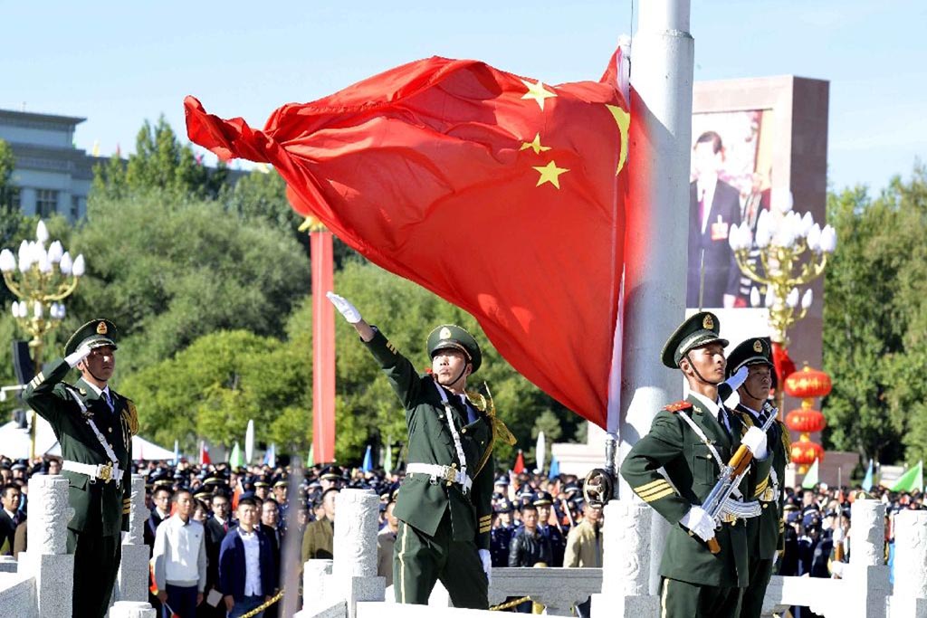 Chinese paramilitary police conduct a flag rising ceremony as thousands of people gather in front of the iconic Potala Palace in the regional capital Lhasa on 8 September 2015, for an event billed as marking 50 years since the founding of the administrative area of Tibet.