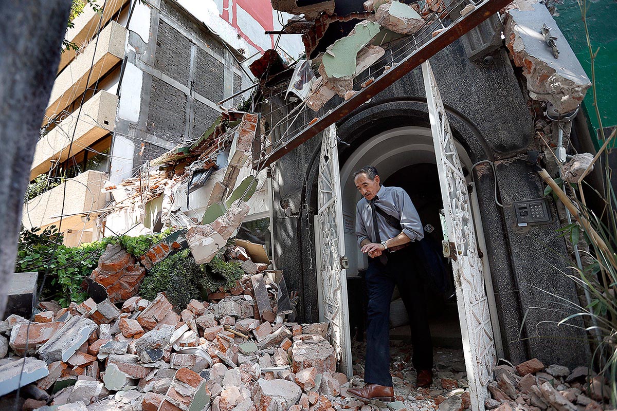 A man walks out of the door frame of a building that collapsed after an earthquake, in the Condesa neighbourhood of Mexico City, on 19 September 2017.