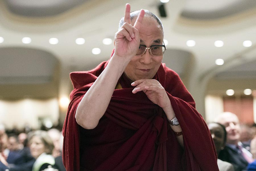 The Dalai Lama gestures a peace symbol as he is introduced during the National Prayer Breakfast in Washington, DC, on 5 February 2015. 