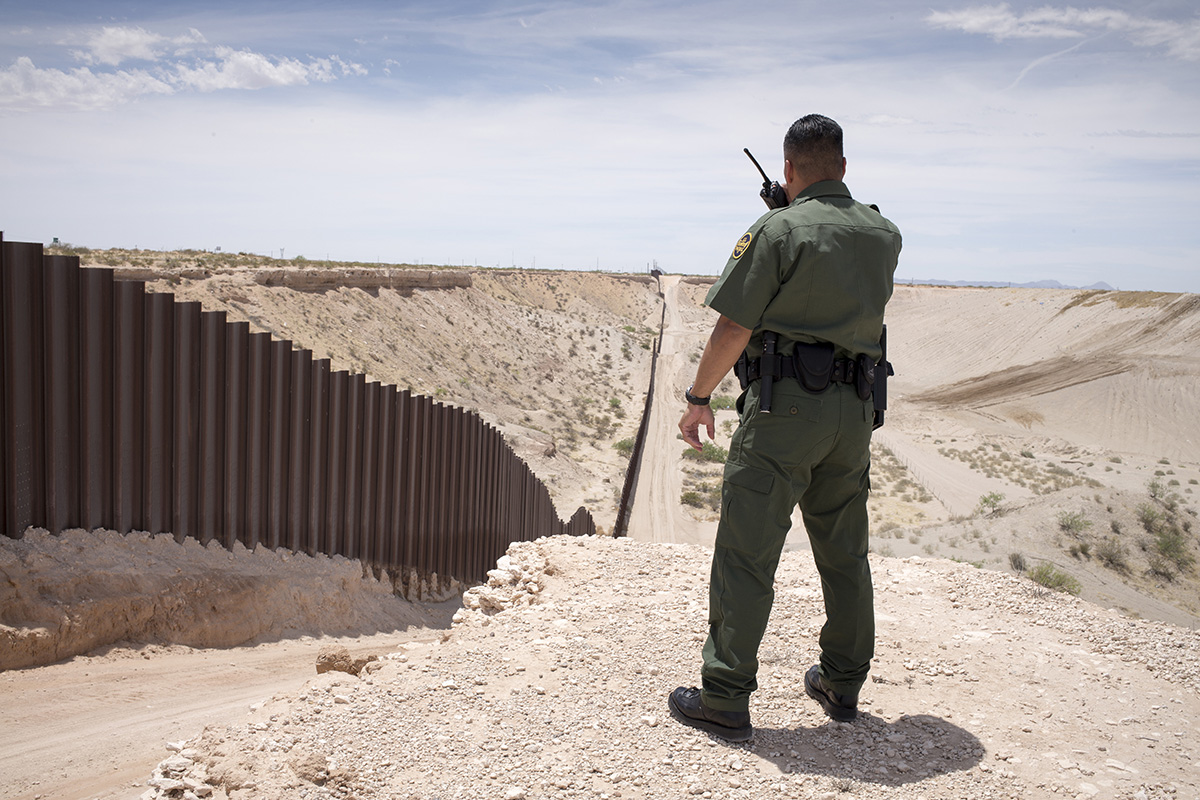 A US Border Patrol agent watches over the border fence on the US and Mexico border near Sunland Park, New Mexico, on May 2014.