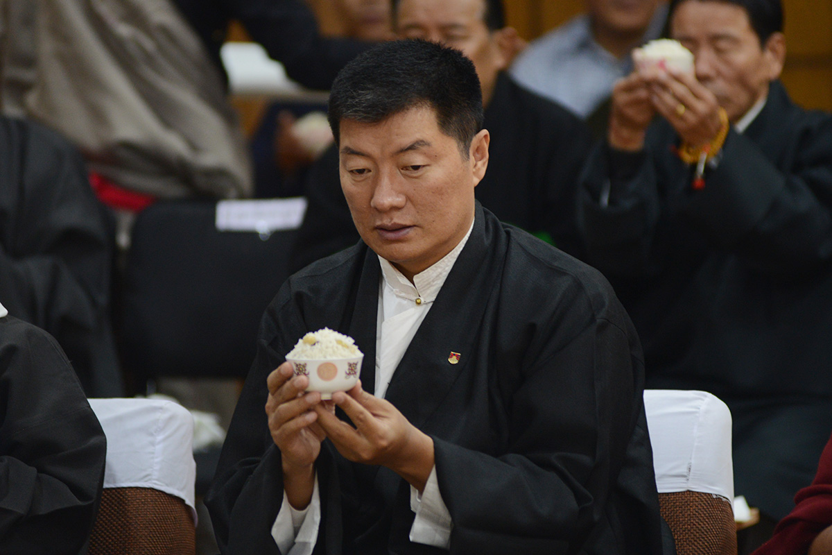 President of the Central Tibetan Administration Lobsang Sangay offers prayer holding a traditional bowl of sweet rice during the swearing-in ceremony of the new Speaker of the Tibetan Parliament-in-exile in Dharamshala, India, on 1 December 2018.