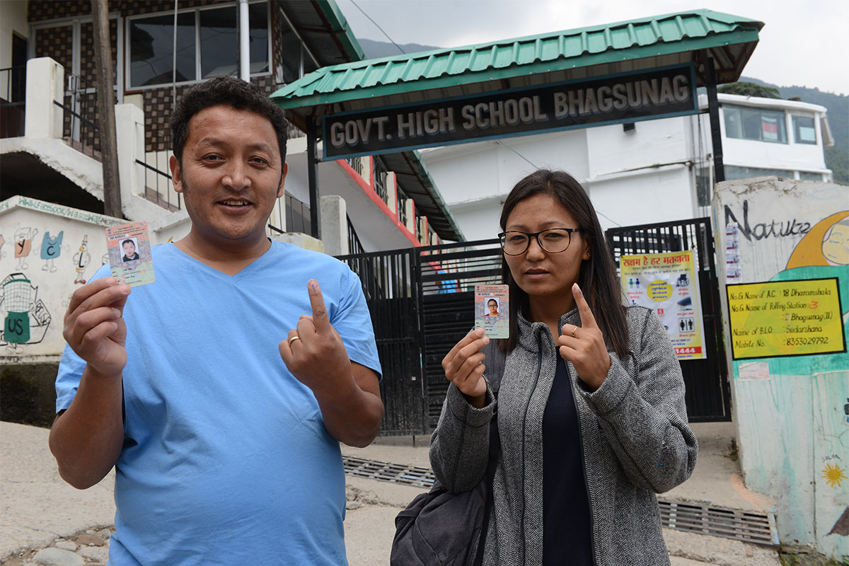 An exiled Tibetan couple Tashi Dhondup and his wife Wangdon show their voter's identity cards and fingers marked with indelible ink after casting vote at a polling station in the seventh and the last phase of Indian general elections in Bhagsu Nath near McLeod Ganj, India, on 19 May 2019.