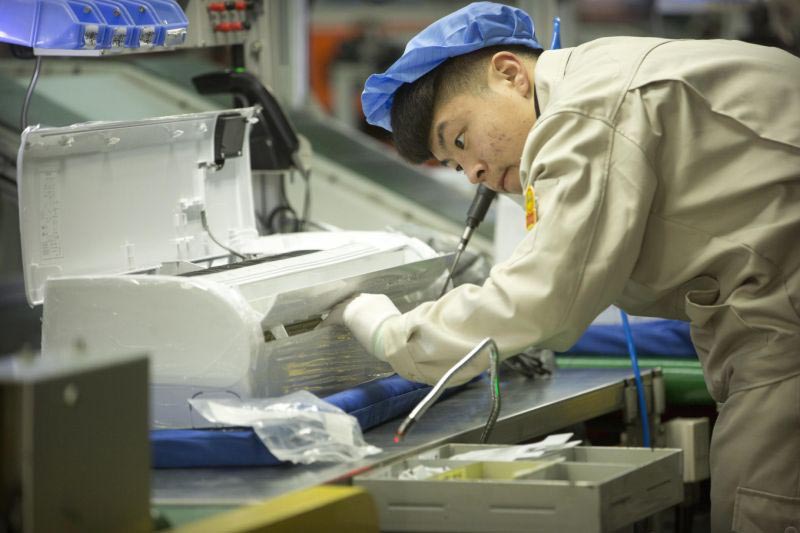 In this 24 February 2017, photo, a factory worker assembles the case of an air conditioner on an assembly line at a Haier factory in Jiaozhou near Qingdao in eastern China's Shandong Province. US President Donald Trump's latest tariff hike on Chinese goods took effect on 10 May 2019, and Beijing said it would retaliate, escalating a battle over China's technology ambitions and other trade tensions.