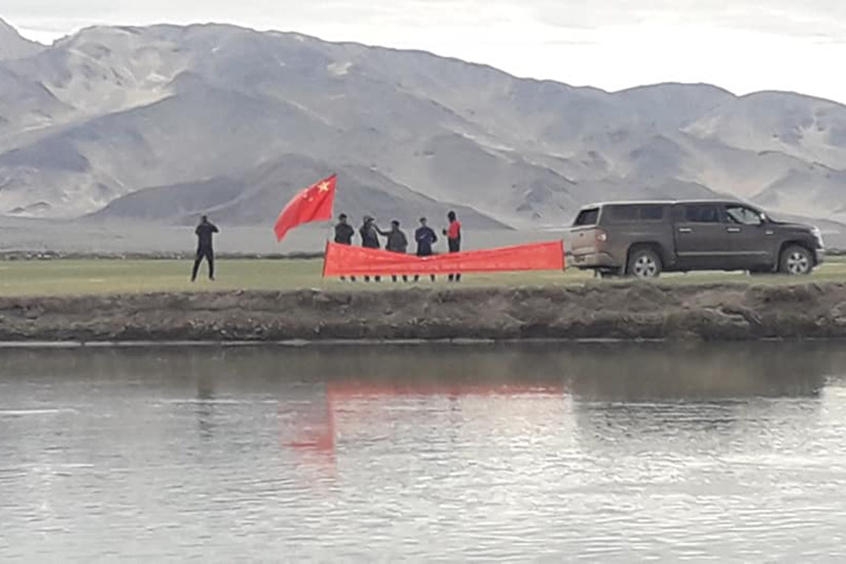 A purported photo of Chinese troops in civilian clothes planting a Chinese flag on Indian territory as residents of a village in Ladakh close to the border celebrate the 84th birthday of the Dalai Lama on 6 July 2019. The banner read 