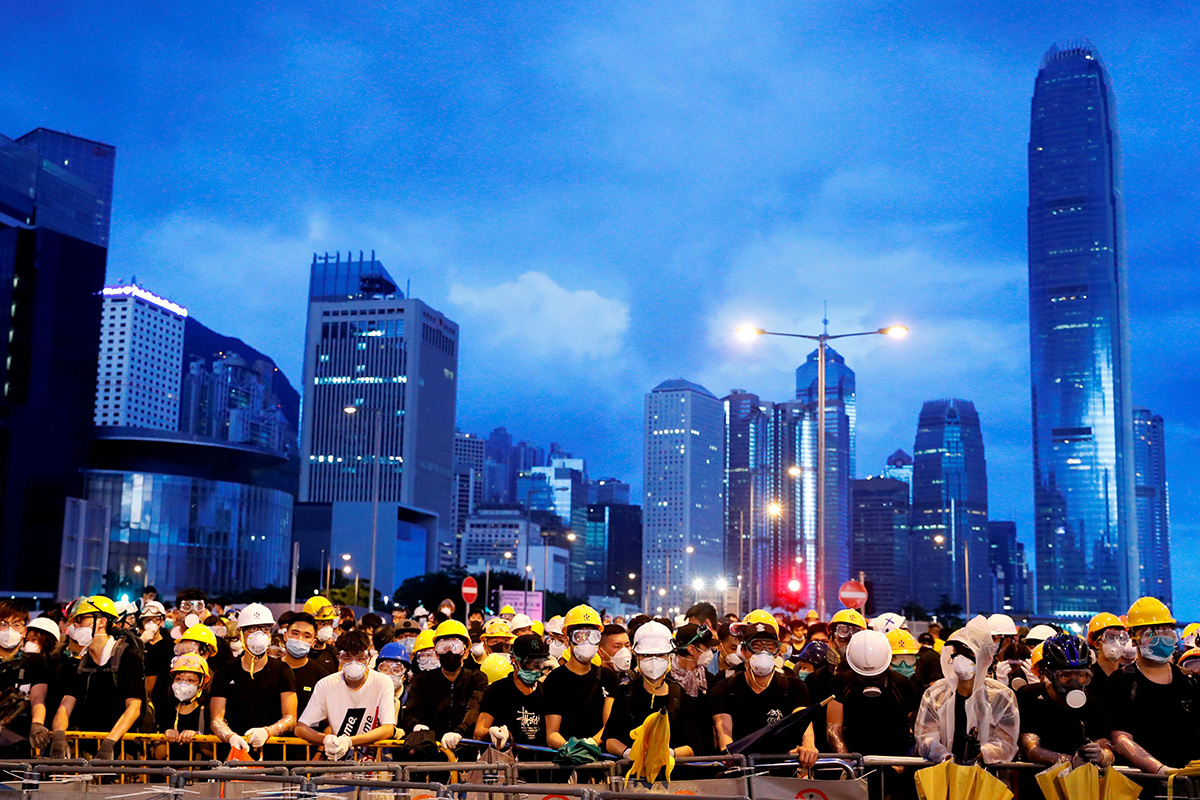 Anti-extradition bill protesters stand behind a barricade during a demonstration near a flag raising ceremony for the anniversary of Hong Kong handover to China in Hong Kong, China on 1 July 2019.