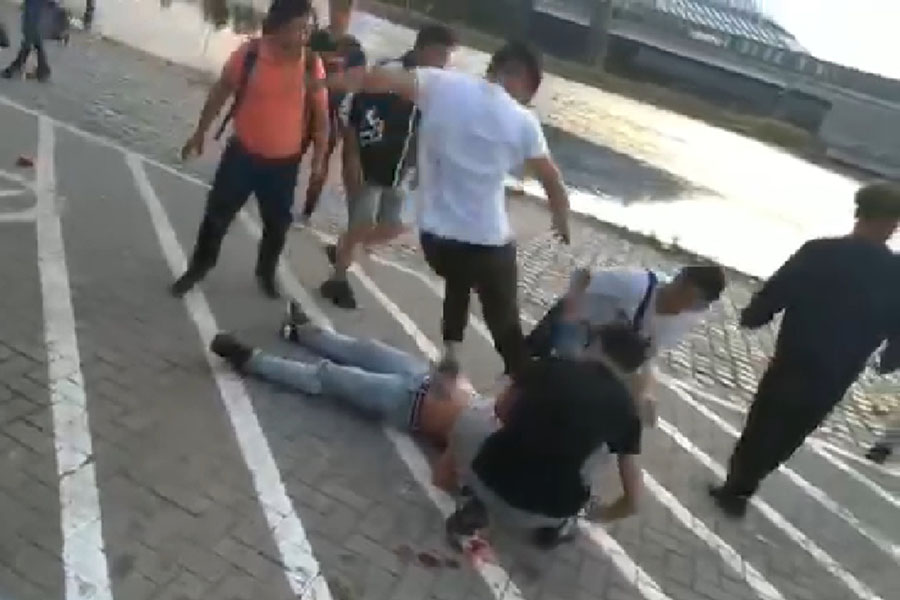 A Tibetan youth from Antwerpen in Belgium kicks another Tibetan youth fallen on the ground near the end of a fight in Antwerpen on early Saturday morning, 20 July 2019.