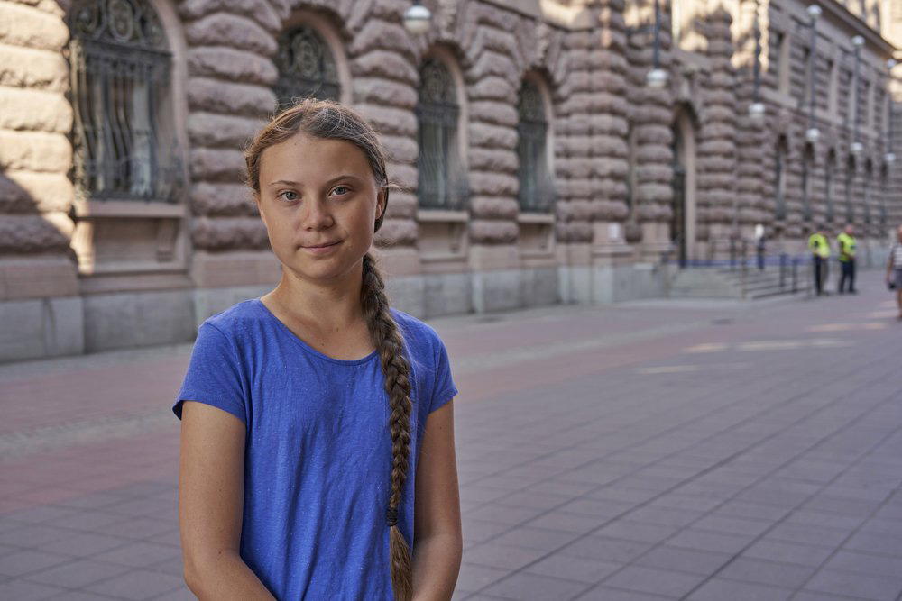 In this photo taken on 26 July 2019, Greta Thunberg stands next to Swedish parliament in Stockholm. Thunberg, the Swedish teenager whose social media-savvy brand of eco-activism has inspired tens of thousands of students in Europe to skip classes and protest for faster action against climate change, said Monday, 29 July 2019 that she plans to take her message to America the old-fashioned way: by boat.