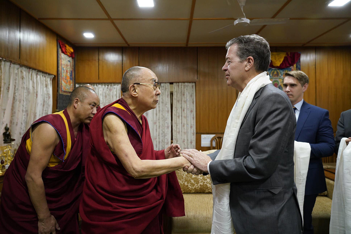 Tibetan spiritual leader the Dalai Lama shakes hands with the US Ambassador at Large for International Religious Freedom, Samuel Dale Brownback, at his residence in McLeod Ganj, India, on 28 October 2019.