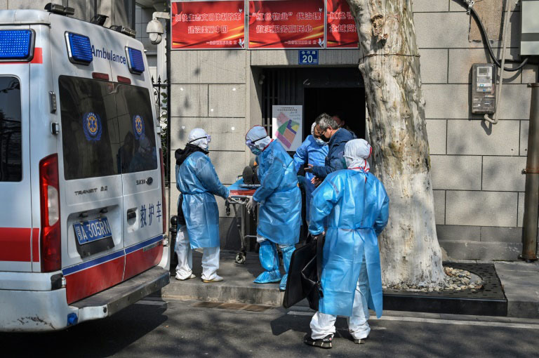 Medical staff in protective clothing carry a suspected virus patient from an apartment in Wuhan.