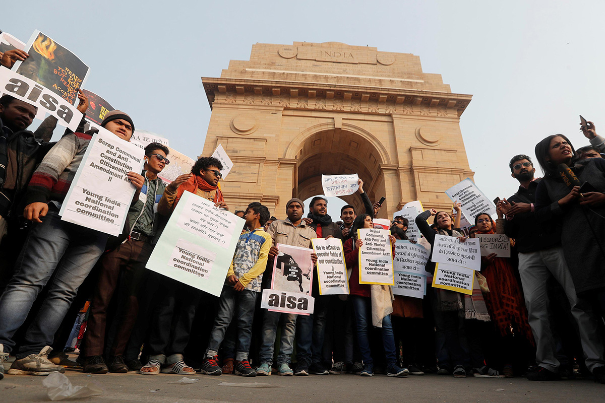 Demonstrators hold placards as they stand in front of the India Gate during a protest against a new citizenship law, in New Delhi, India, on 1 January 2020.