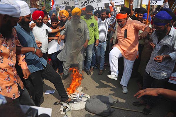 Indian Sikh protestors stamp on a burning effigy of Pakistan Prime Minister Imran Khan during a protest against the alleged vandalism and stoning of the Nankana Saheb, a Sikh shrine in Pakistan, in Hyderabad, India, on 5 January 2020.