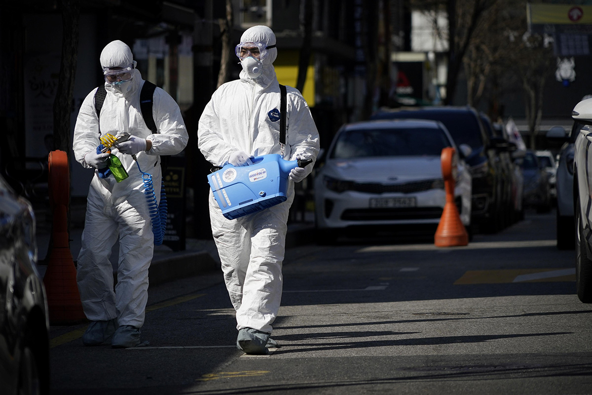 Employees from a disinfection service company sanitize a shopping district in Seoul, South Korea, on 27 February 2020.