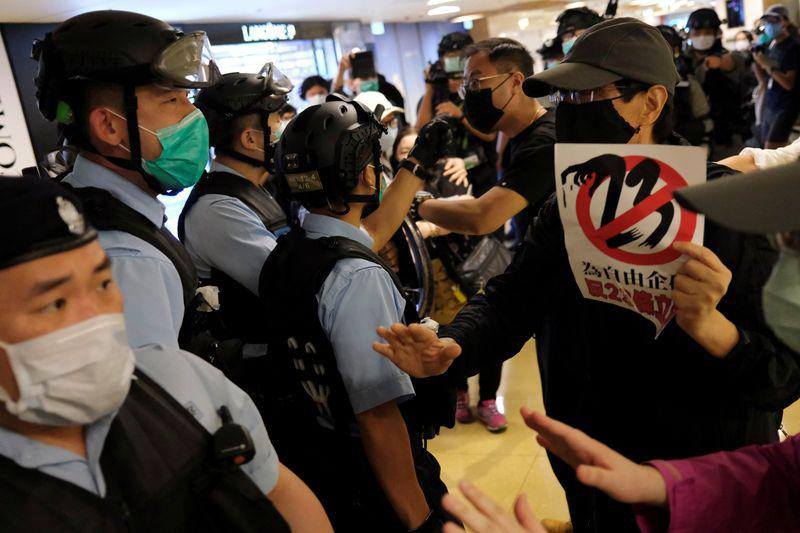Riot police wearing face masks to avoid the spread of the coronavirus disease (COVID-19) argue with anti-government protesters as they stage a rally at a shopping mall, in Hong Kong, China, on 26 April 2020.