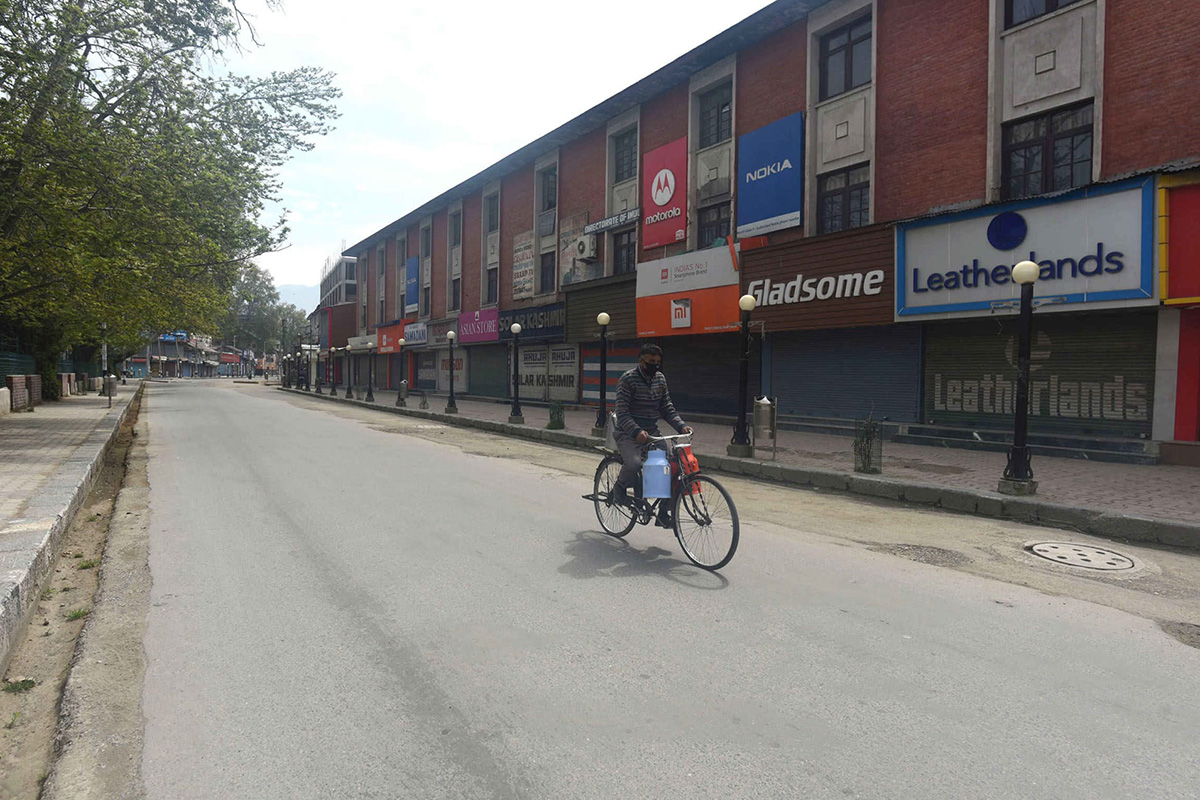 A lone cyclist rides past shuttered shops in Lal Chowk during the lockdown in Srinagar, India, on 14 April 2020.
