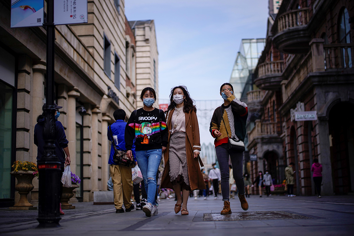 People wearing face masks are seen at a main shopping area after the lockdown was lifted in Wuhan, capital of Hubei province and China's epicentre of the novel coronavirus disease (COVID-19) outbreak, on 14 April 2020. 