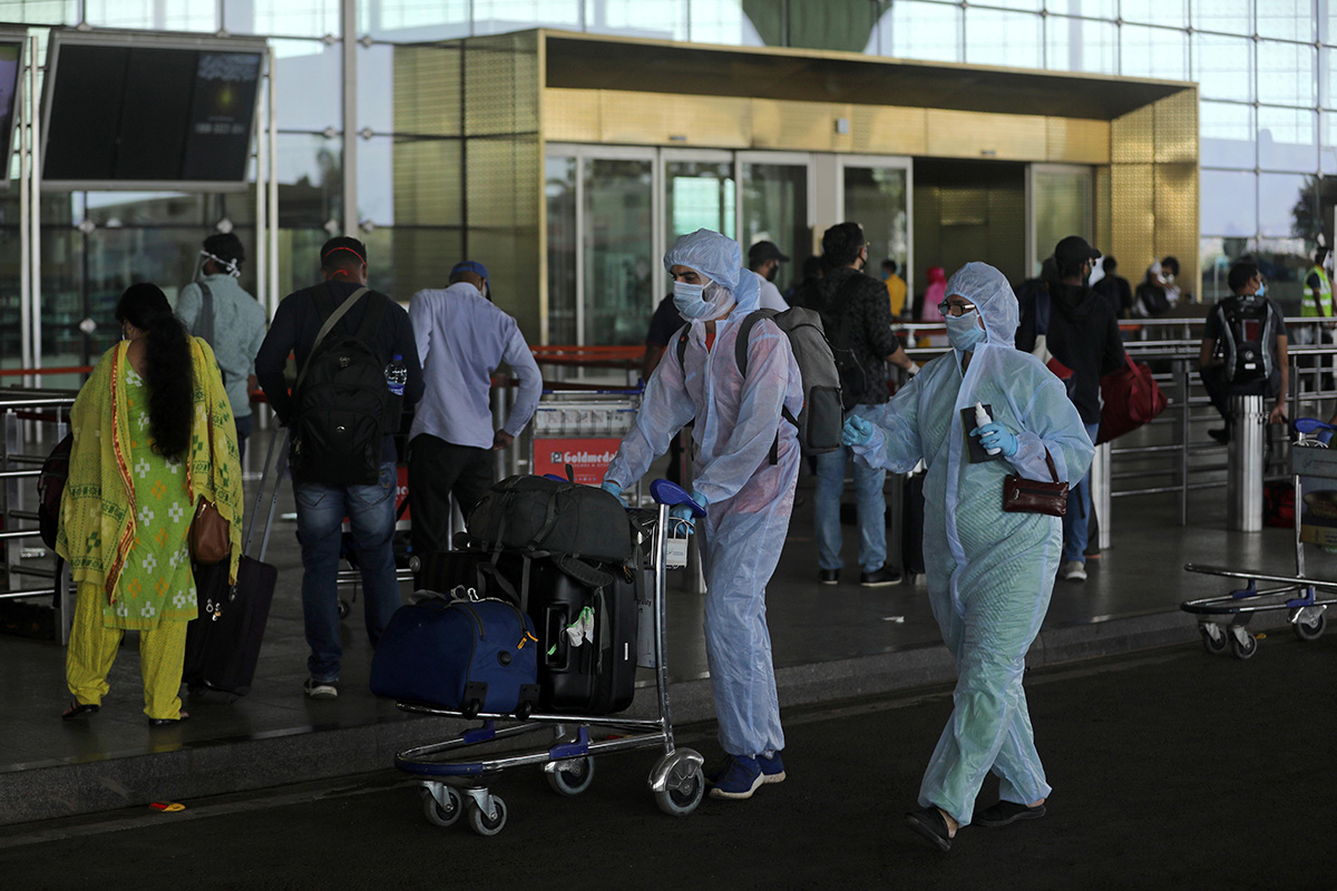 Passengers wearing personal protective equipment (PPE) enter Chhatrapati Shivaji International Airport, after the government allowed domestic flight services to resume, during an extended nationwide lockdown to slow the spread of the coronavirus disease (COVID-19), in Mumbai, India, on 25 May 2020.