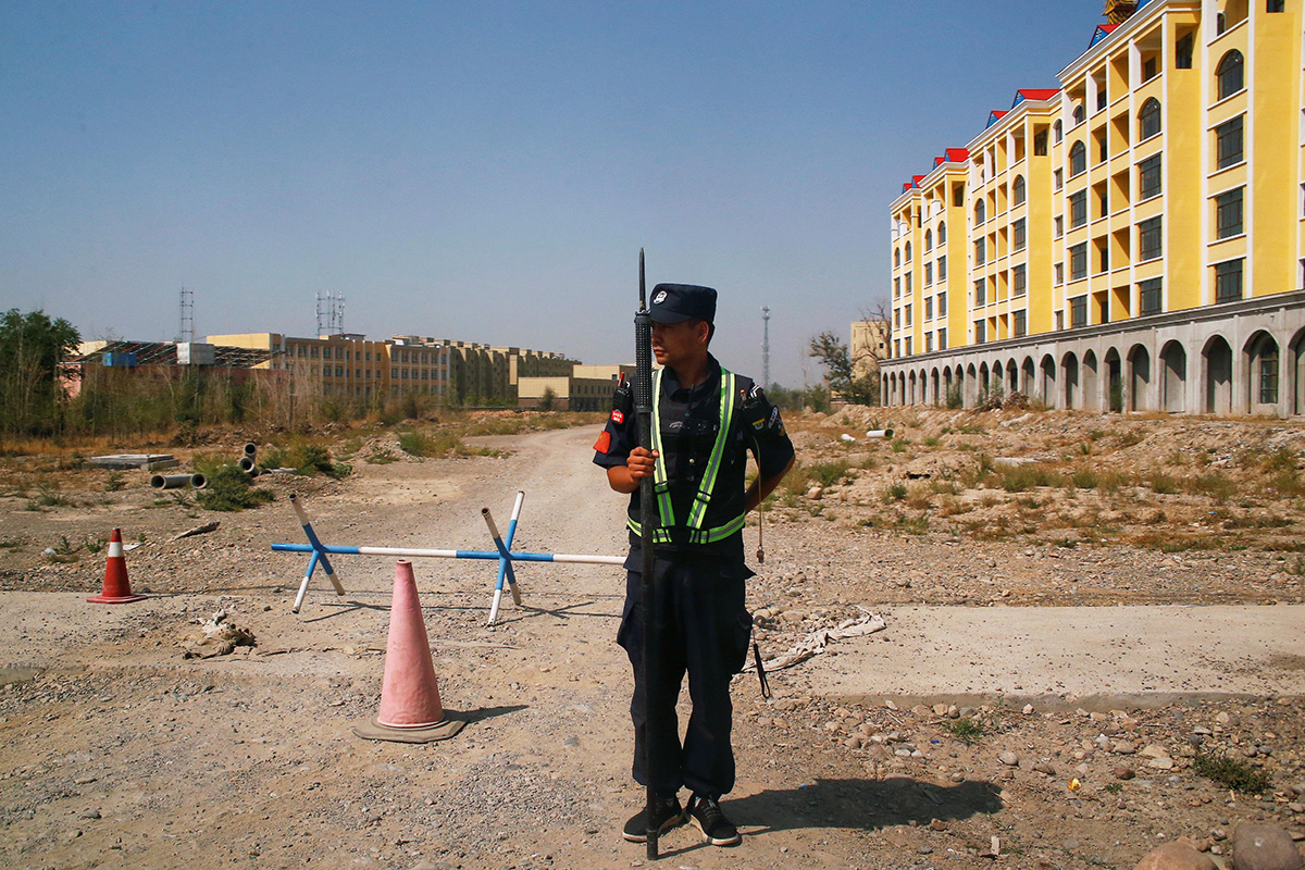 A Chinese police officer takes his position by the road near what is officially called a vocational education centre in Yining in Xinjiang Uyghur Autonomous Region, China, on 4 September 2018.