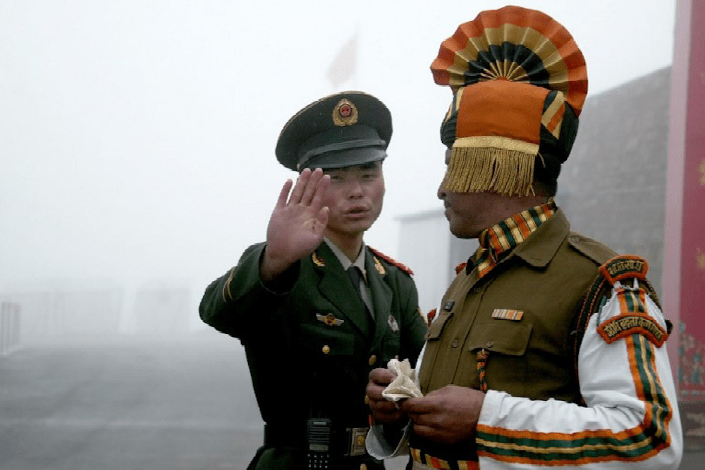 This file photo taken on 10 July 2008 shows a Chinese soldier (L) next to an Indian soldier at the Nathu La border crossing between India and China in India’s northeastern Sikkim state.
