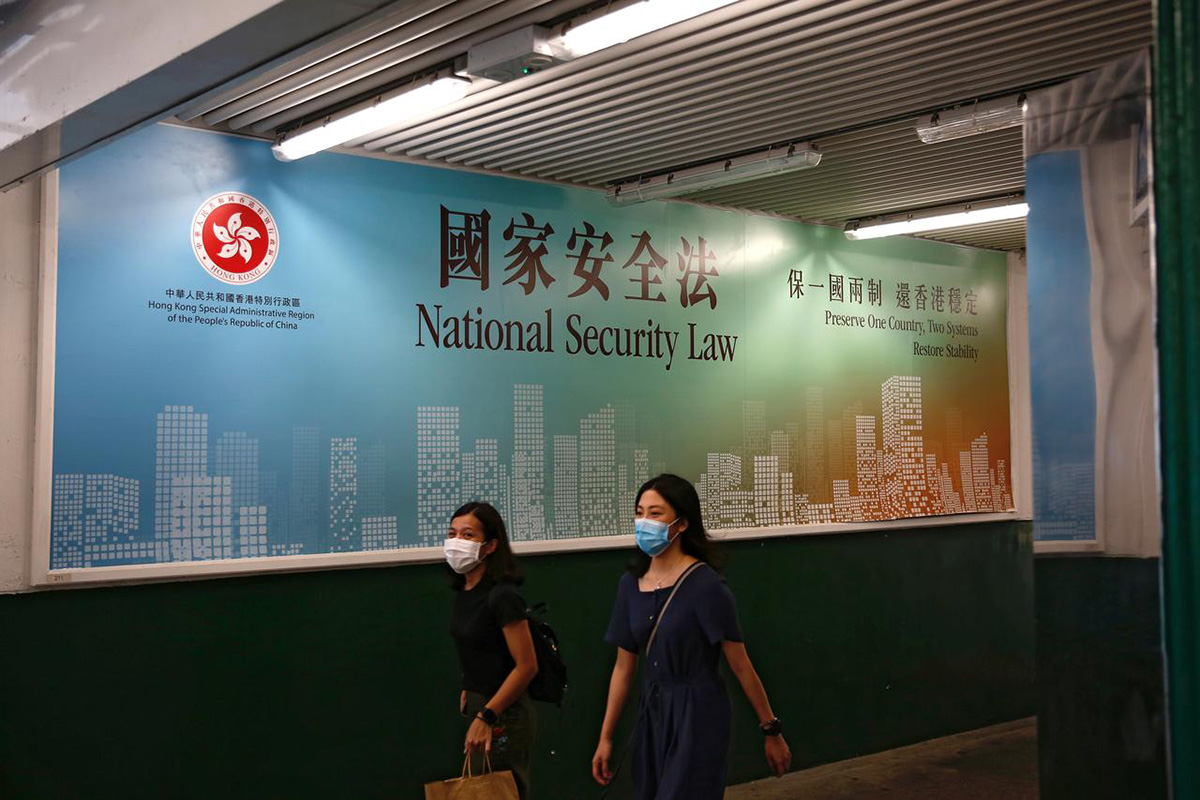 Women walk past a government-sponsored advertisement promoting the new national security law as a meeting on national security legislation takes place in in Hong Kong, China, on 29 June 2020.